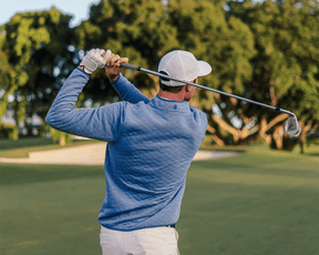 Golfer in The Sullivan Quarter-Snap pullover, showcasing its quilted design and casual style on a fairway, highlighting its versatility and performance.