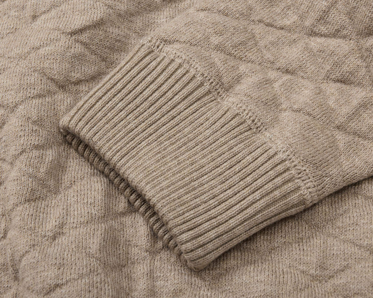 The Ward Crewneck Sweater: Heathered Light Dune, showcasing a ribbed cuff and sleeve in a textured diamond jacquard knit pattern, made from premium Egyptian cotton.