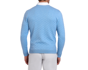 The Ward Crewneck Sweater: Heathered Vista Blue features a diamond-quilt pattern, shown on a man over a white shirt, paired with gray pants.