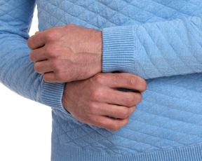 The Ward Crewneck Sweater: Heathered Vista Blue, featuring a diamond jacquard pattern, worn with sleeves down, showcasing its soft, premium Egyptian cotton knit.