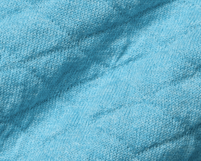 Close-up of The Wallace Hoodie Sweater: Heathered Harbor, showcasing the intricate light-blue knit texture and ribbed side panels in 100% Egyptian cotton.
