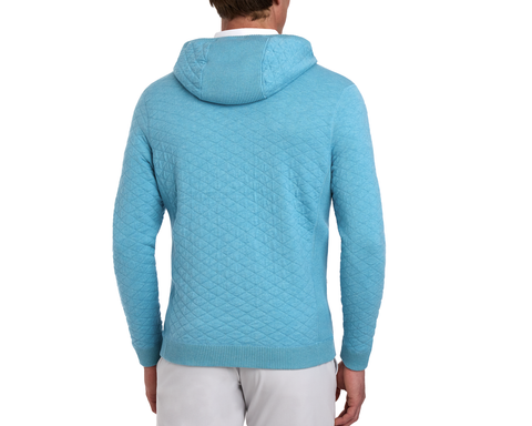 Person wearing The Wallace Hoodie Sweater: Heathered Harbor, showcasing a light-blue quilted texture, ribbed cuffs, and hem, paired with light trousers from behind.