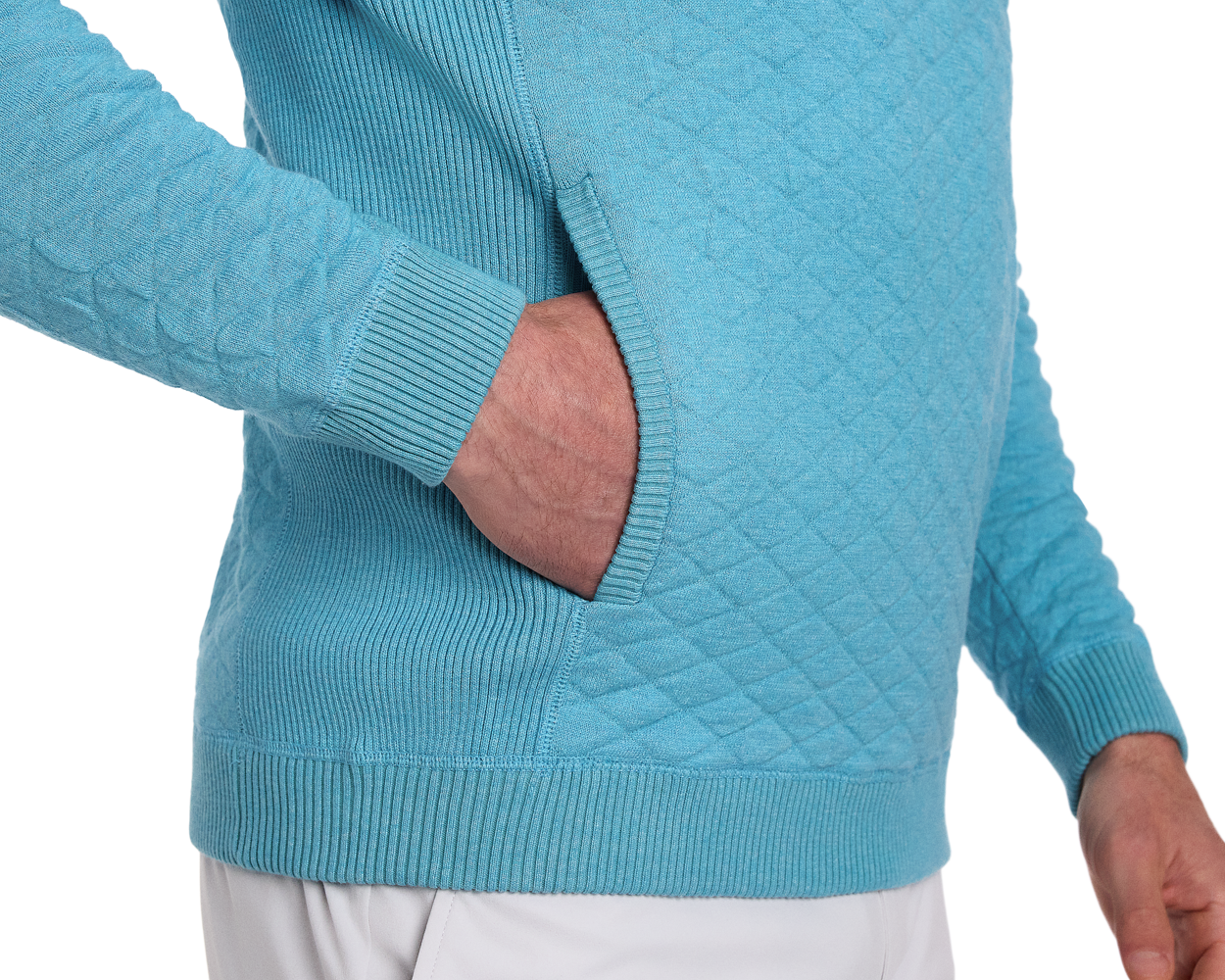 Person wearing The Wallace Hoodie Sweater: Heathered Harbor, a diamond-quilted pullover with ribbed cuffs, hem, and a kangaroo-style pocket, hand tucked inside.