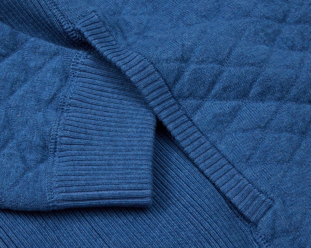The Wallace Hoodie Sweater features a quilted knit texture with ribbed cuffs, crafted from 100% Egyptian cotton for a modern, warm design.