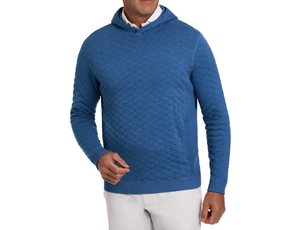 The Wallace Hoodie Sweater in Heathered Maidstone Blue, showcasing a diamond-quilted design over a white shirt, paired with light trousers.