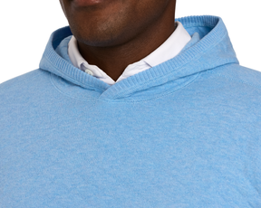 Person in The Wallace Hoodie Sweater: Heathered Vista Blue, showing a light-blue hood and shoulders over a white collared shirt, highlighting its modern, streamlined design.