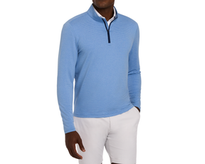 Man wearing The Royce Quarter-Zip: Heathered Horizon Blue, a textured long-sleeve pullover with dark-trim collar, paired with beige shorts, hand in pocket.