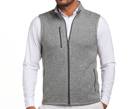 The Ashby Vest: Heathered Gray, a sleeveless zip-front vest with a standing collar, zippered pockets, worn over a white collared shirt, showcasing versatile style and comfort.