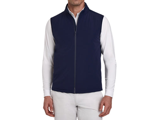 The Swenson Vest: Navy, shown on a male model, offers a sleek, sleeveless design with zip-front, ideal for warmth and flexibility on the golf course.