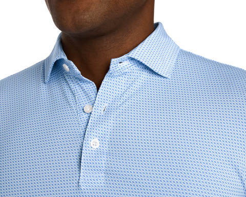Close-up of The Norman Shirt: Vista Blue & Horizon Blue, showcasing its spread collar, unbuttoned white button, and subtle geometric pattern on a light-blue fabric.