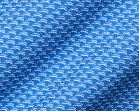 The Eaton Shirt: Horizon Blue, showcasing a close-up of its soft, stretchy fabric with a white, semi-circular wave pattern, designed for moisture wicking and sun protection.