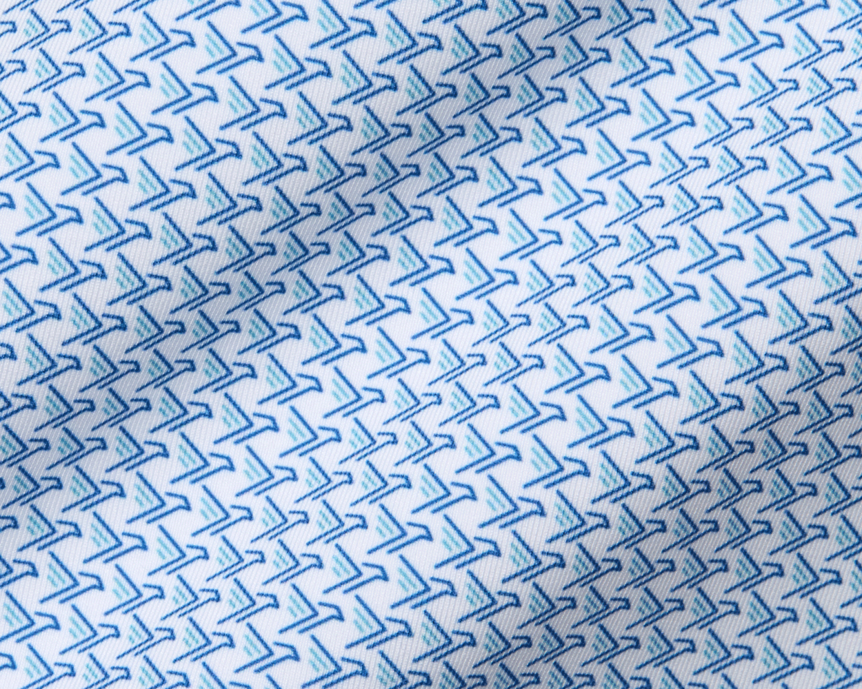 The Justice Shirt: Harbor & Maidstone Blue, features a white fabric with small, angular blue boomerang motifs, offering four-way stretch and breathability.