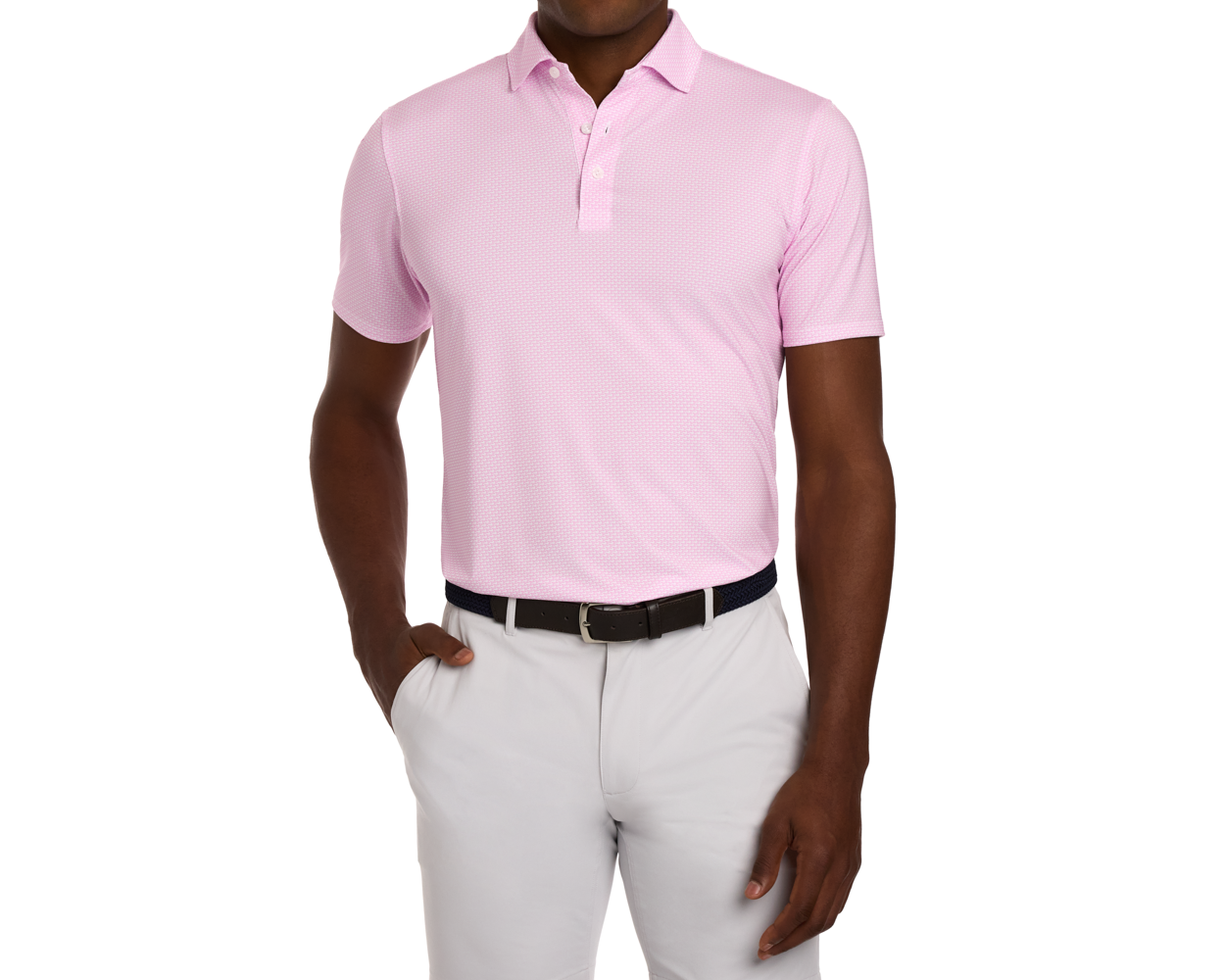 The Hanover Shirt: Belmont, a light-pink polo with geometric pattern, features a structured collar and four-way stretch, worn with grey trousers and a woven belt.