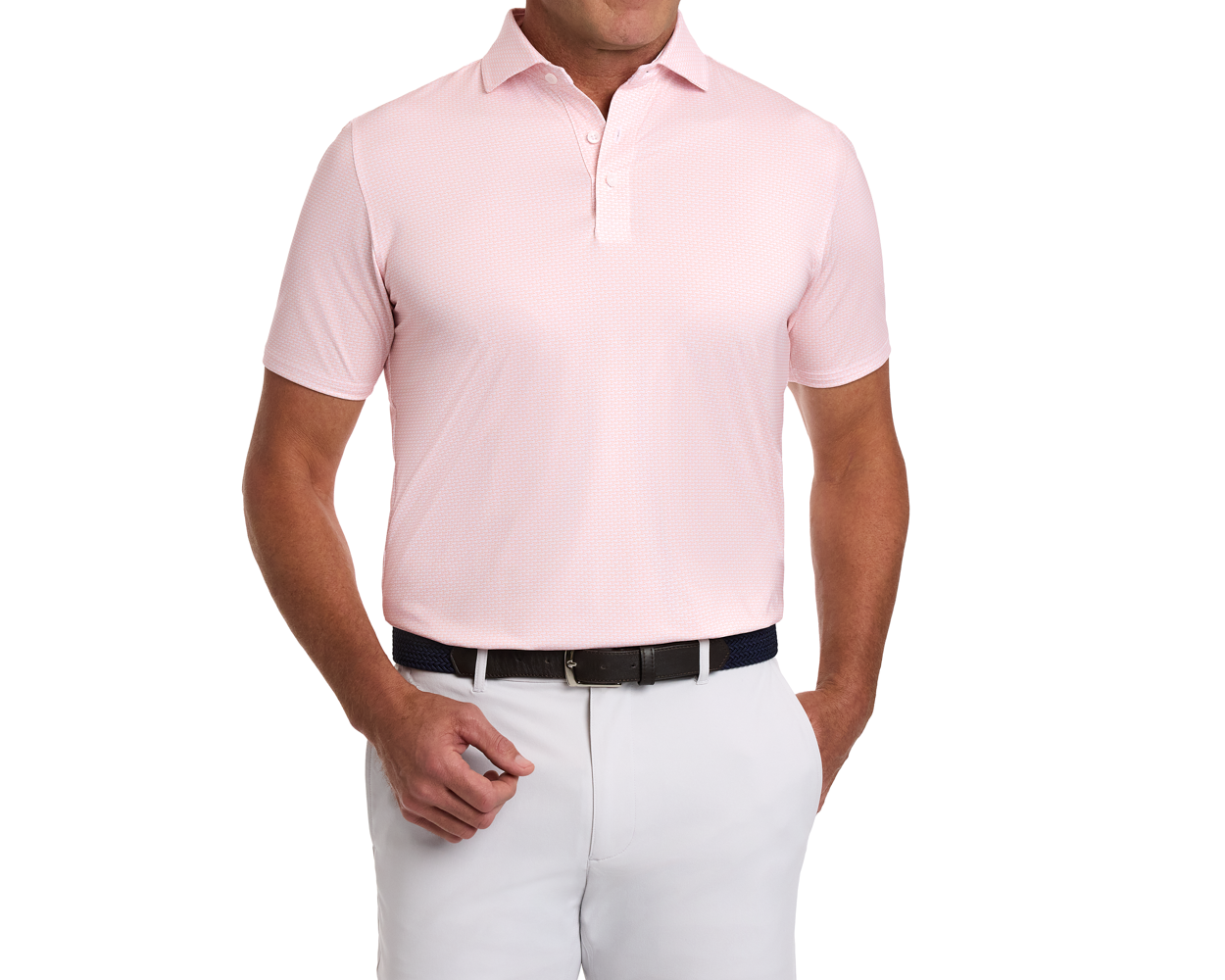 Model wearing The Hanover Shirt: Nectarine, a light pink polo with a geometric pattern, tucked into pants, accessorized with a dark woven belt.