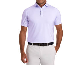 The Hanover Shirt: Tudor showcased in a geometric pattern, short-sleeve polo design, tucked into trousers, highlighting its structured spread collar and comfortable fit.
