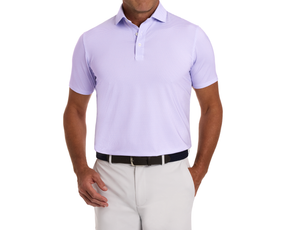 The Hanover Shirt: Tudor, a light lavender polo with a subtle texture, worn tucked into light trousers, featuring a dark woven belt and metal buckle.