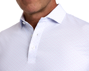 The Cadogan Shirt: Tudor & Vista Blue features a breathable polo with lilac-toned pattern, classic collar, and two-button placket.