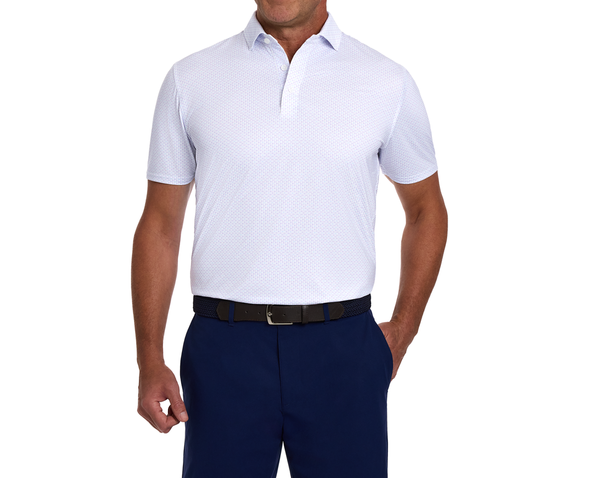 Man wearing The Cadogan Shirt: Tudor & Vista Blue, a breathable, short-sleeve polo with a structured spread collar, tucked into navy trousers.