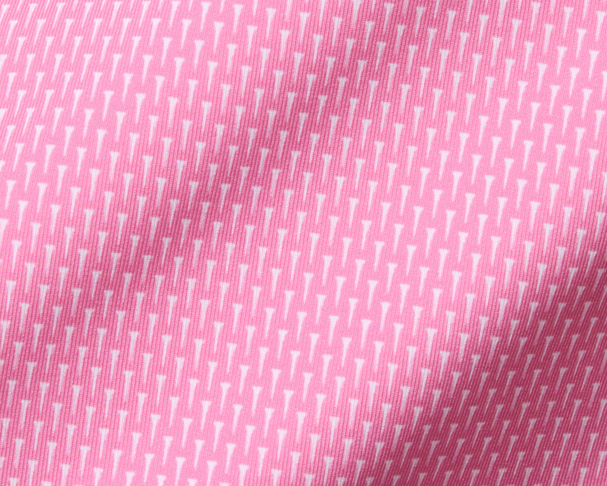 Close-up of The Hicks Boys Shirt: Belmont, showcasing its pink woven fabric with tiny white golf-tee motifs, highlighting its stretchy, moisture-wicking performance jersey.
