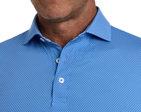 The Hicks Shirt: Horizon Blue, featuring a blue button-down with a geometric golf-tee pattern, visible on a man's upper torso and neck.