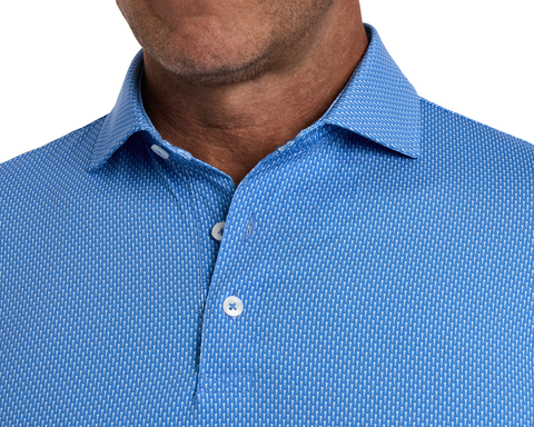 The Hicks Shirt: Horizon Blue, featuring a blue button-down with a geometric golf-tee pattern, visible on a man's upper torso and neck.