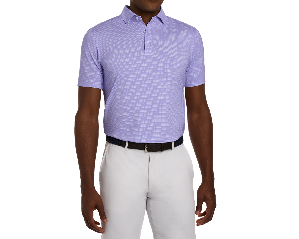 The Hicks Shirt: Tudor, featuring a geometric golf-tee pattern, spread collar, and performance jersey, worn tucked into trousers with a dark woven belt.