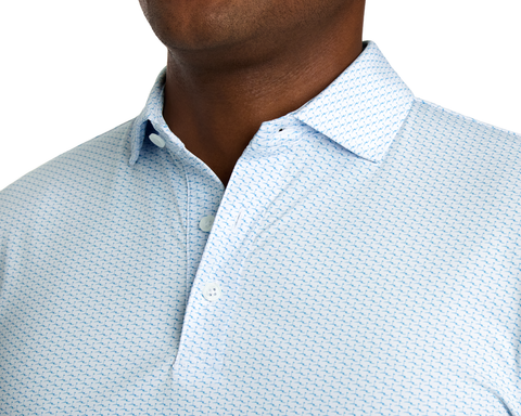 The Atwood Shirt: Harbor features a light-blue polo with a navy pattern, two-button placket, and soft collar, offering moisture-wicking and UPF 50+ protection.