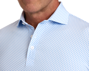 The Atwood Shirt: Horizon Blue, featuring a light blue with dark blue geometric pattern, open collar, structured spread collar, and part of a man's tanned jawline.
