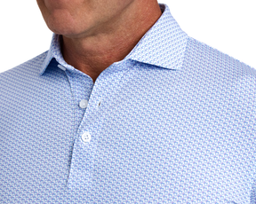 The Fulton Shirt: Belmont & Horizon Blue features a white polo with blue thumbs up print, showcasing a structured collar and performance jersey fabric.