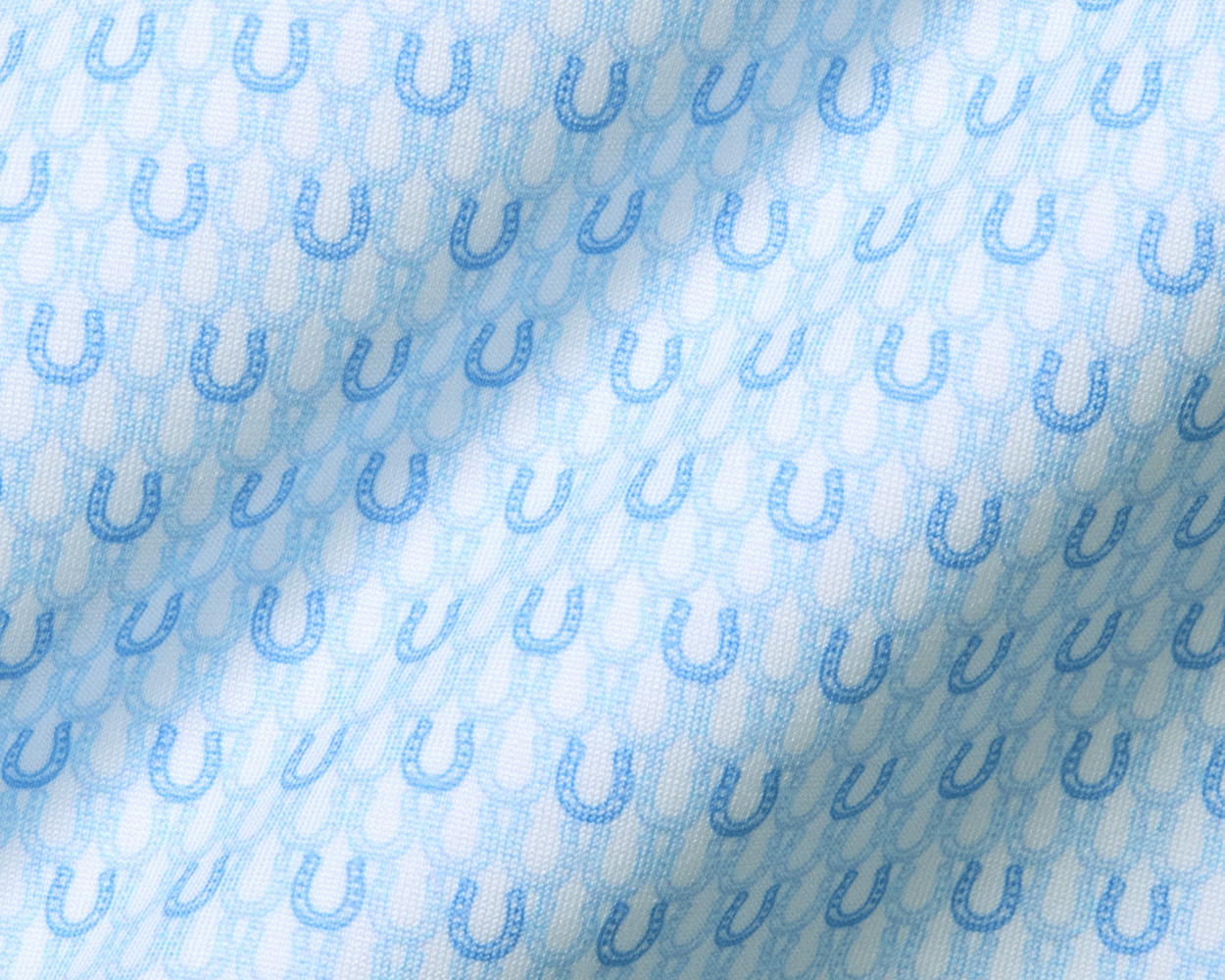 The Rivers Shirt: Vista Blue & Horizon Blue, featuring a soft jersey fabric with light-blue horseshoe motifs on a subtle background, showcasing its breathable, moisture-wicking design.