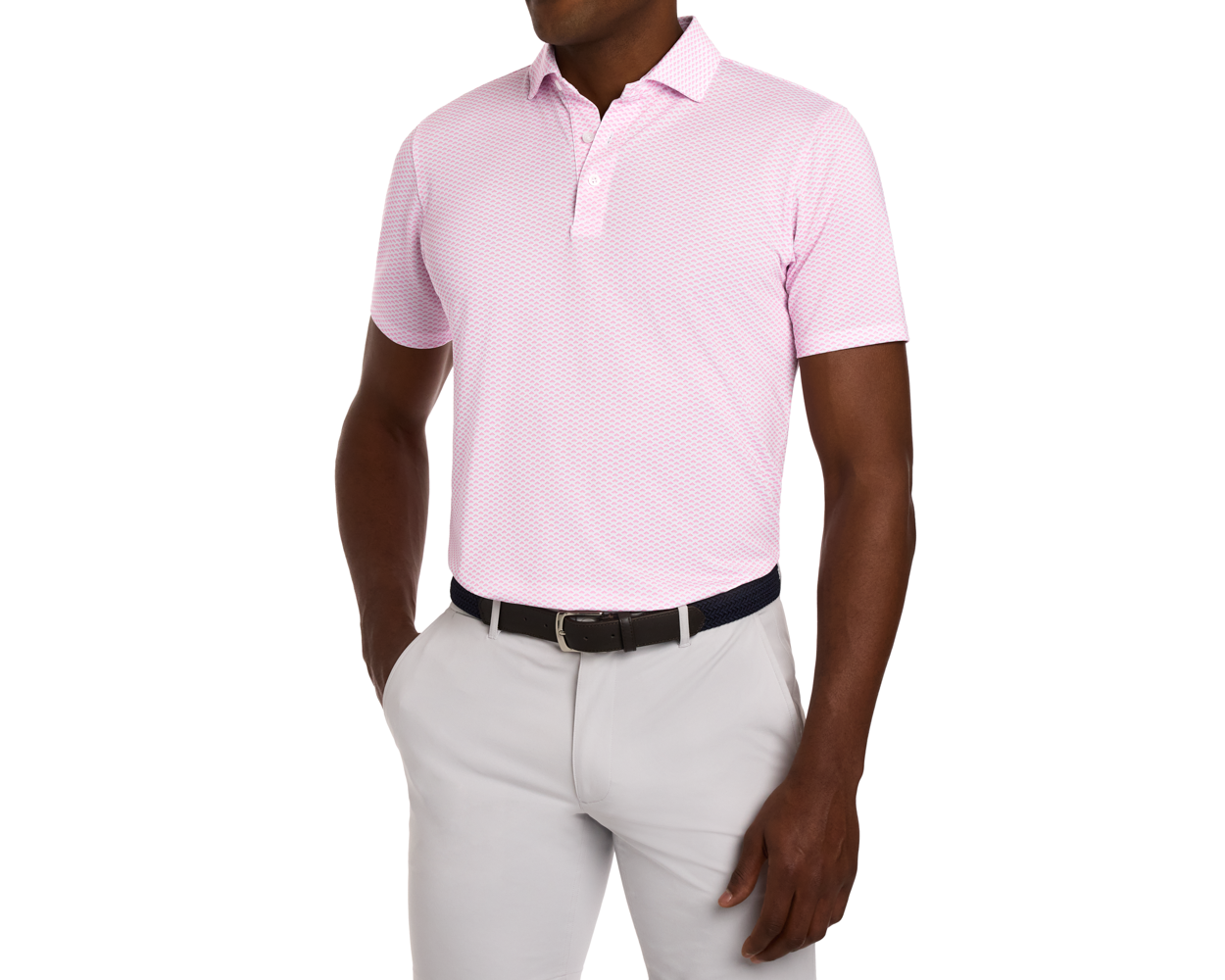 Model wearing The Geiger Shirt: Belmont, a light pink polo with geometric pattern, tucked into light gray trousers, featuring a woven belt and UPF 30+ protection.