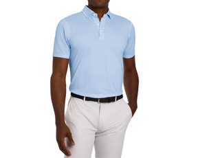 The Geiger Shirt: Maidstone Blue with a light-blue abstract pattern, short sleeves, and structured collar, paired with light gray trousers and a black belt.
