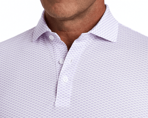 The Geiger Shirt: Tudor features a patterned polo with a structured collar, three-button placket, and breathable pique fabric, offering comfort and UPF 30+ protection.