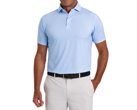 The Griffin Shirt: Horizon Blue, featuring a subtle griffin pattern, worn with light trousers and a navy woven belt, highlighting its versatile, performance-focused design.