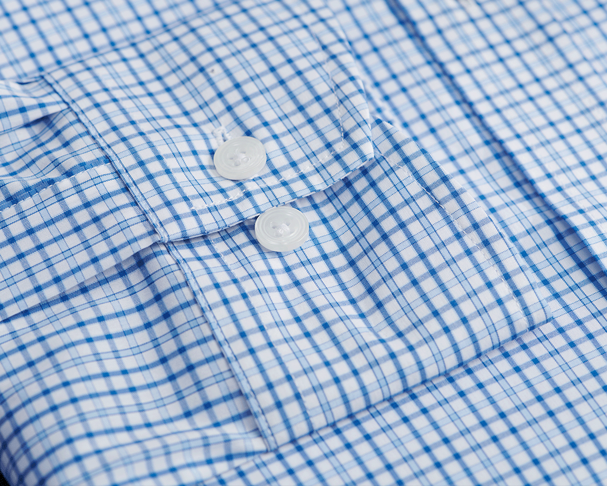 The Wright Shirt: Vista Blue, showcasing a crisp plaid pattern, button-front, spread collar, and clear buttons, made of breathable, wrinkle-resistant cotton-blend poplin.