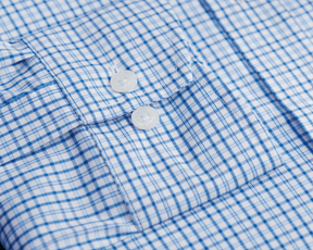 The Wright Shirt: Vista Blue, showcasing a crisp plaid pattern, button-front, spread collar, and clear buttons, made of breathable, wrinkle-resistant cotton-blend poplin.