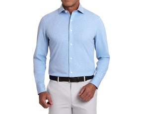 The Cullinane Shirt: Heathered Vista Blue, a light-blue, long-sleeve, button-front shirt, worn tucked into light gray trousers with a dark belt.