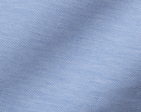 The Cullinane Shirt: Heathered Maidstone Blue features a close-up of its light-blue piqué texture, showcasing breathable knit and stylish, polished comfort.