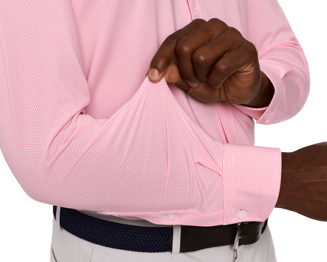 Person wearing The Goodrich Shirt: Belmont in pink, showcasing its stretch and drape, with a geometric pattern, tucked into light trousers with a belt.