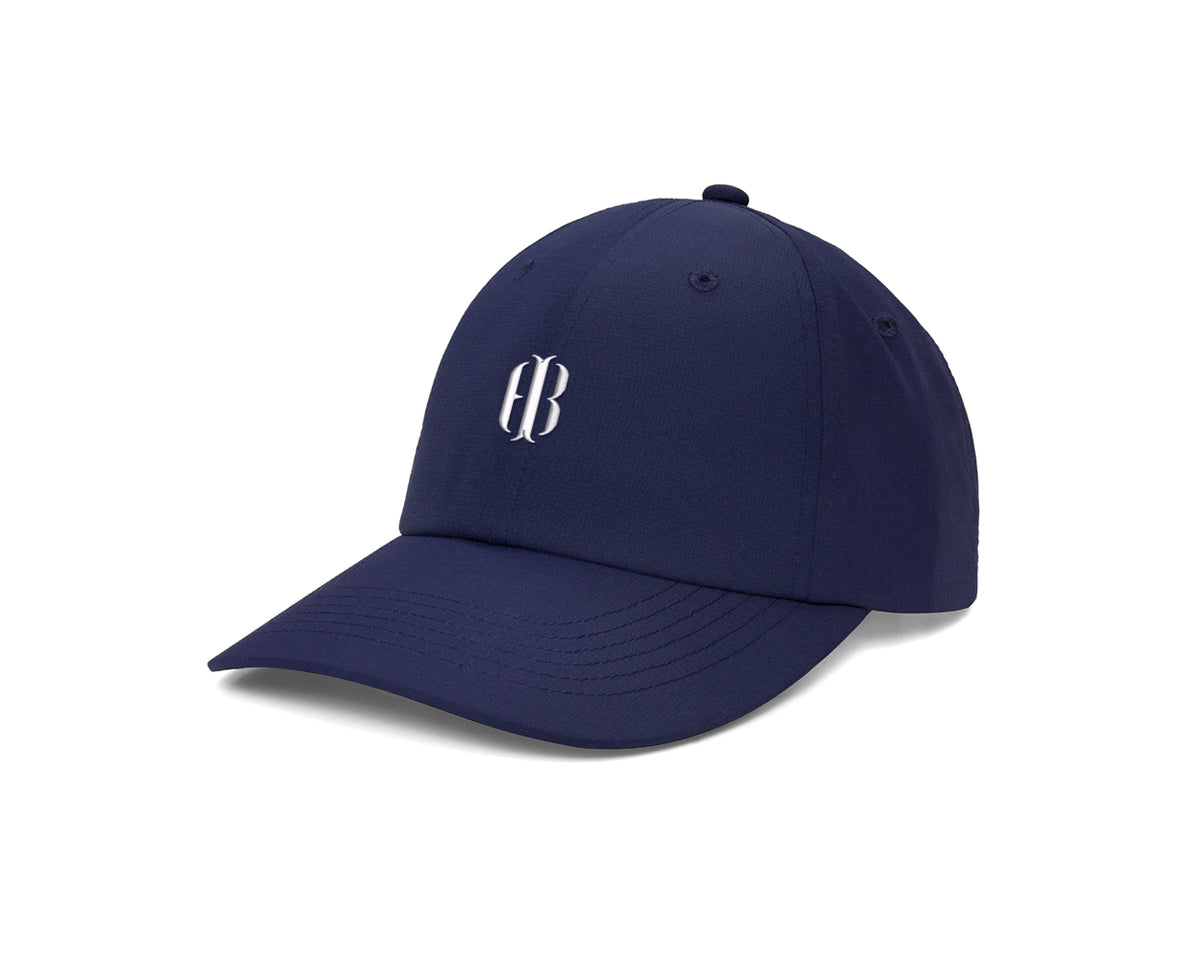 Navy-blue baseball cap with curved brim, featuring a white monogram. The SAP OS Test Product offers adjustable fit, moisture-wicking, and UPF 50+ protection for sunny days.
