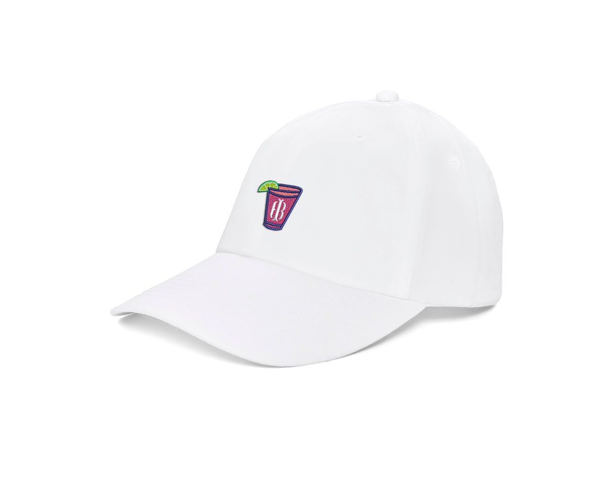 The Lightweight Cotton Hat: White with Transfusion Icon showcases a white cap featuring a colorful drink patch and lime, offering comfort with UPF 50+ protection.