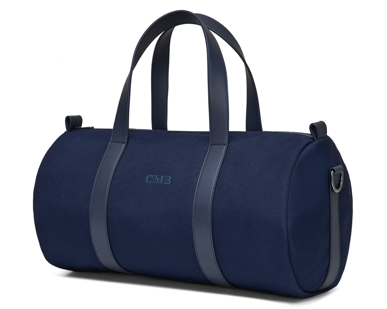 The Marston Banker Bag: Navy Ballistic - Navy Embroidery, a navy-blue canvas duffel with leather trim, monogram CMB, and metal D-rings for an optional strap.