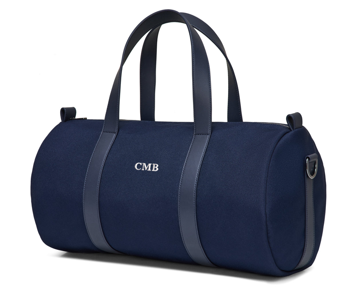 The Marston Banker Bag: Navy Ballistic - White Embroidery, a navy-blue canvas duffel with leather straps, monogrammed CMB, featuring gunmetal hardware and an interior pocket.