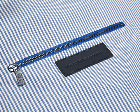 Close-up of The Byers Duffel Bag's interior, showcasing a blue-and-white striped lining with a zipper and HOLDERNESS & BOURNE branded leather label.