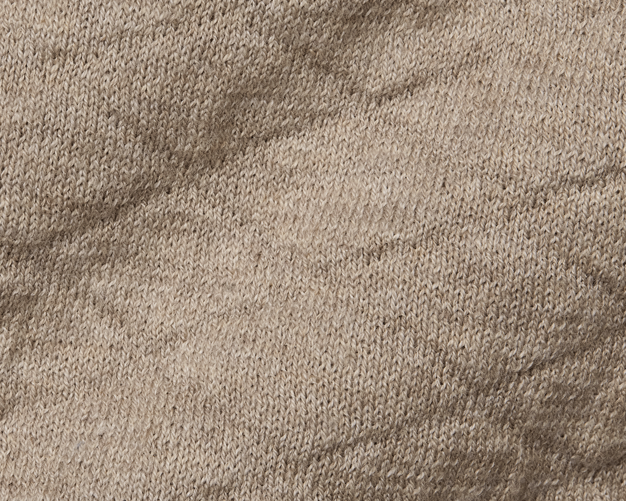 Close-up of The Wallace Hoodie Sweater: Heathered Light Dune, showcasing intricate knit stitches and texture in 100% Egyptian cotton, highlighting its quality and warmth.