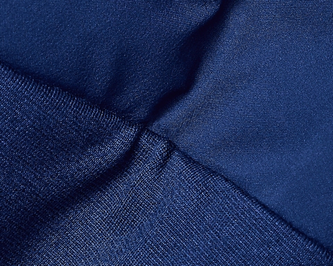Close-up of The Brodie Jacket: Navy, showcasing dark blue synthetic knit fabric with visible seam, highlighting its technical stretch for comfort and movement.