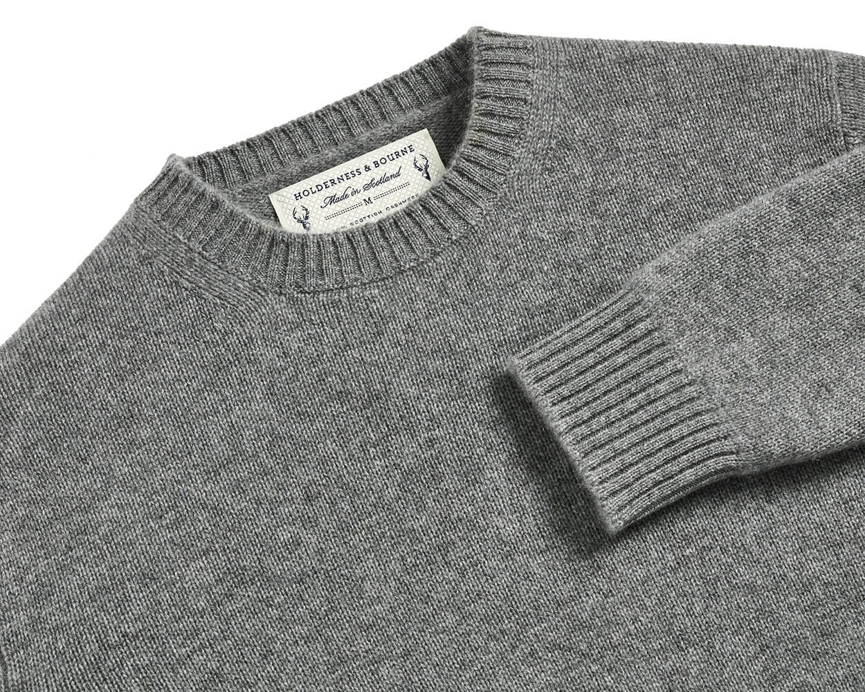The Berwick Crewneck Sweater: Heathered Gray, folded, featuring medium-weight jersey stitch, ribbed collar and cuff, with label showing Holderness & Bourne – 100% Scottish Cashmere.