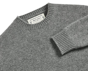 The Berwick Crewneck Sweater: Heathered Gray, folded, featuring medium-weight jersey stitch, ribbed collar and cuff, with label showing Holderness & Bourne – 100% Scottish Cashmere.