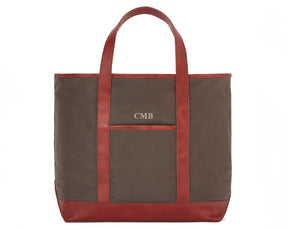 The Travis Tote Bag Cotton Twill: Scotch Green - Rye Embroidery, features a brown canvas with leather trim, monogrammed CMB above a front pocket.