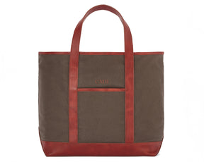 The Travis Tote Bag Cotton Twill features brown canvas with red leather trim, long handles, a front pocket, and CMB initials embroidered.